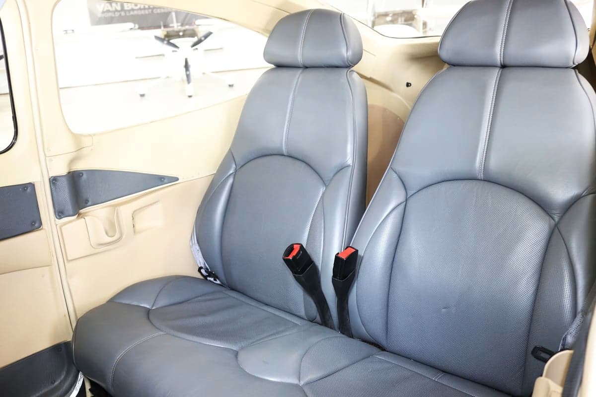 Gray leather seats in the cabin of an aircraft.
