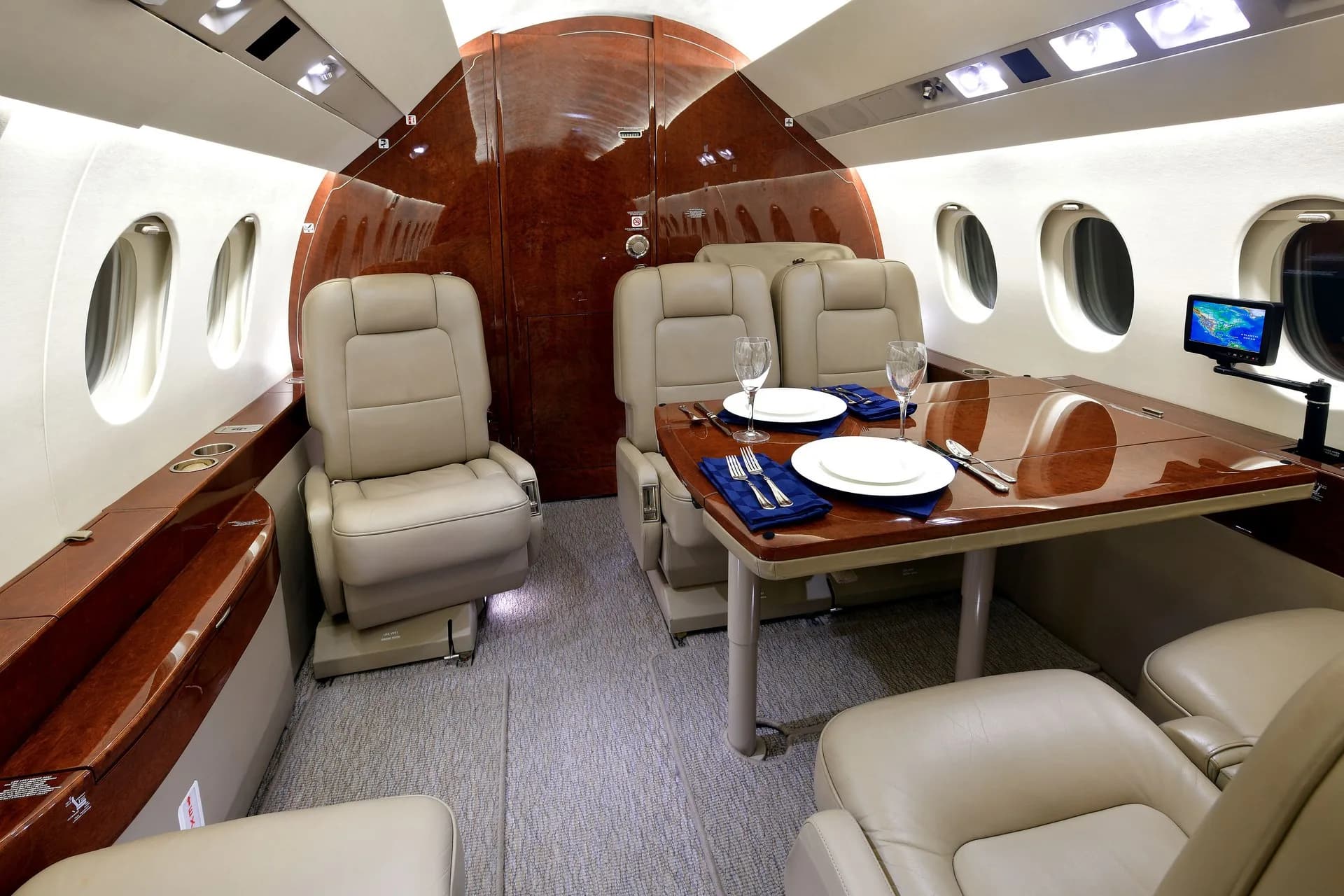 View of the aircraft's interior cabin with leather seats and a dining table set for a meal.