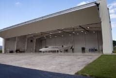 Learjet parked inside an open hangar.