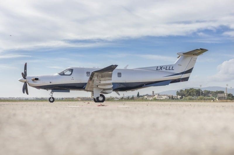 A Pilatus PC-12 aircraft with registration LX-LLL parked on the tarmac.