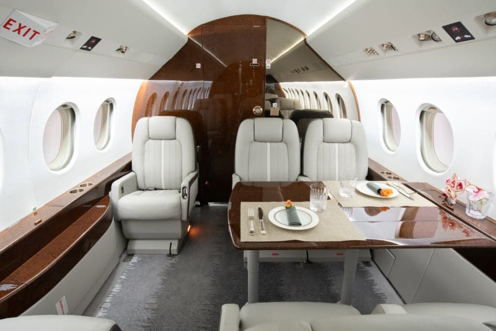 View of the aircraft interior with a dining table set for a meal.