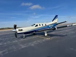 A TBM 930 aircraft with a blue and white paint scheme on the tarmac.