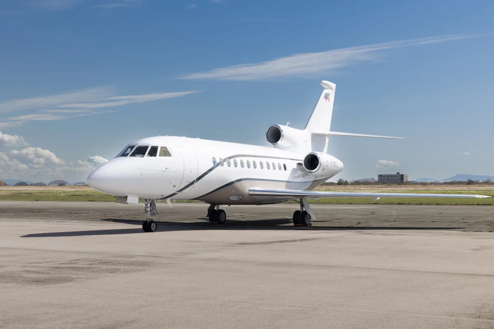 Side view of a white Falcon 2000 on the tarmac.