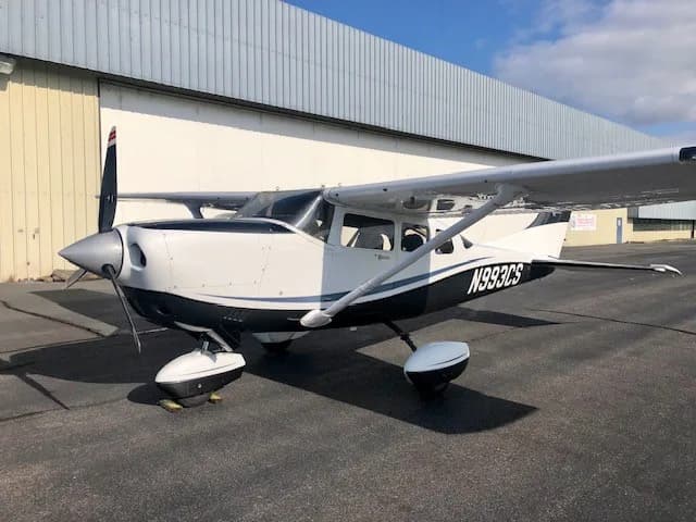 Cessna Stationair N993CS parked on the tarmac with a hangar in the background.