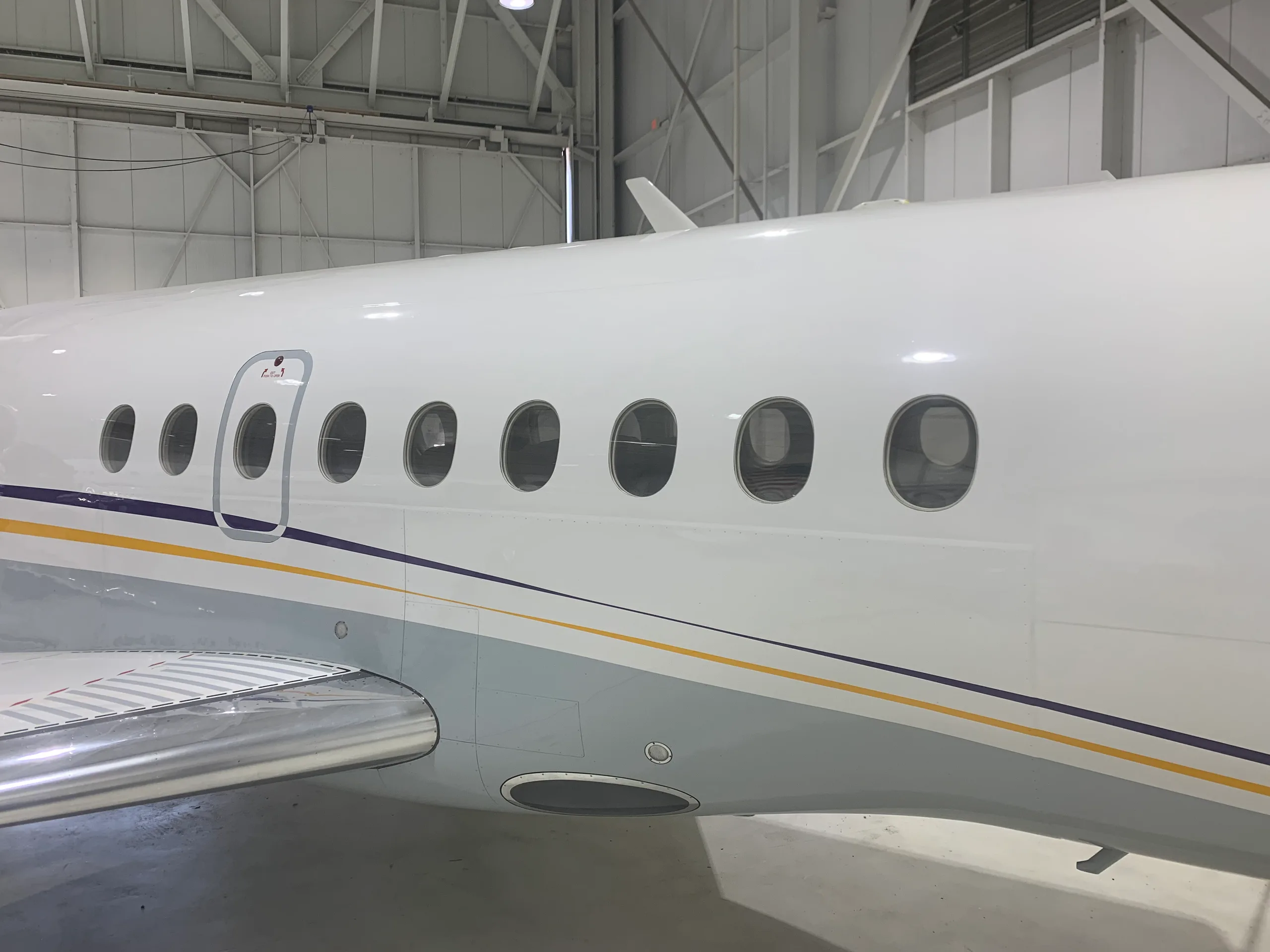 Close-up of the aircraft's windows and white paint scheme with blue and gold accents.
