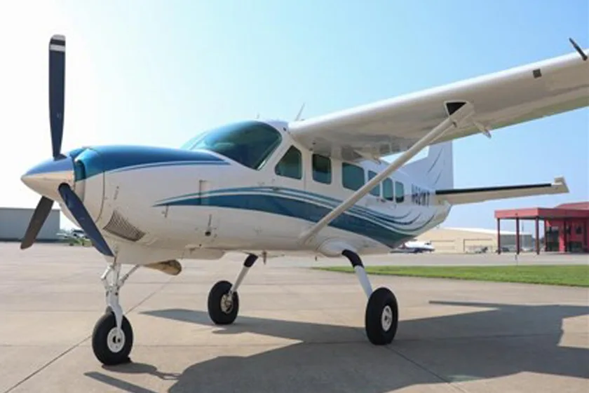 Cessna 208 Caravan with a blue and white paint scheme on the tarmac.