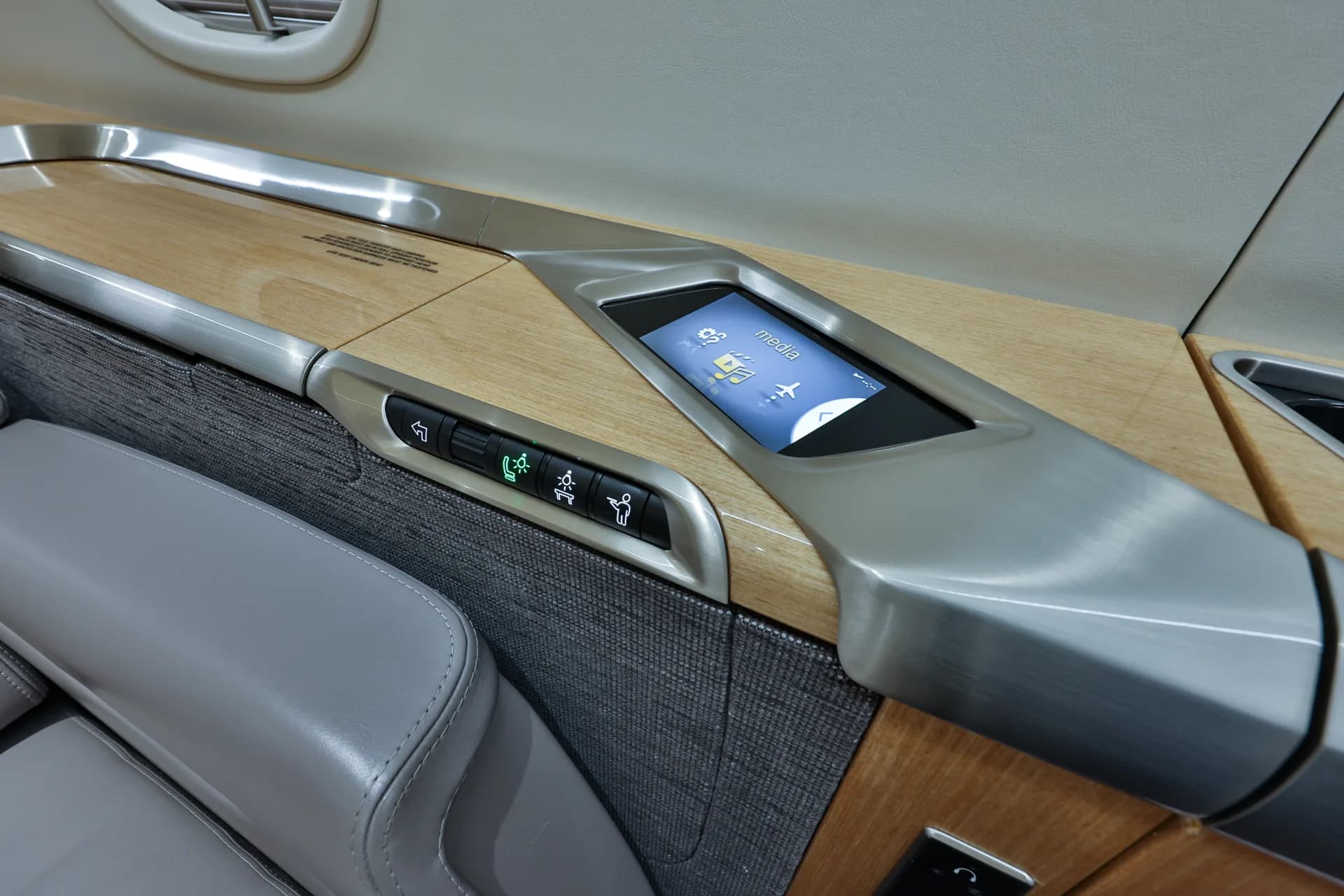 Close up of the side console of a Challenger aircraft seat with a control panel.