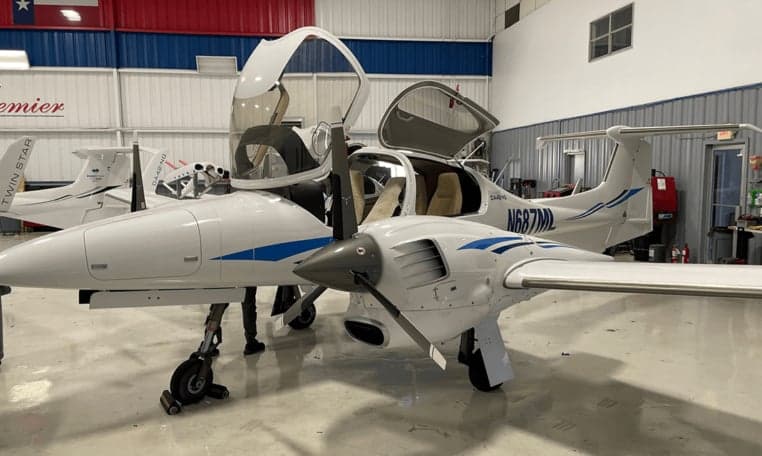 Diamond DA42-NG aircraft N687ML with open doors inside a hangar.
