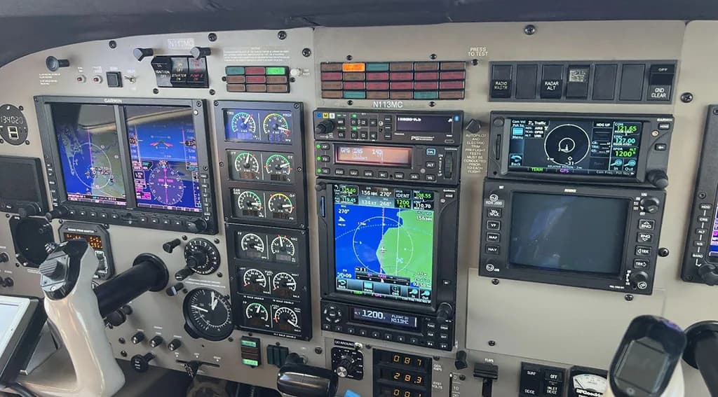 The modern glass cockpit of an aircraft, featuring multiple digital displays and controls.