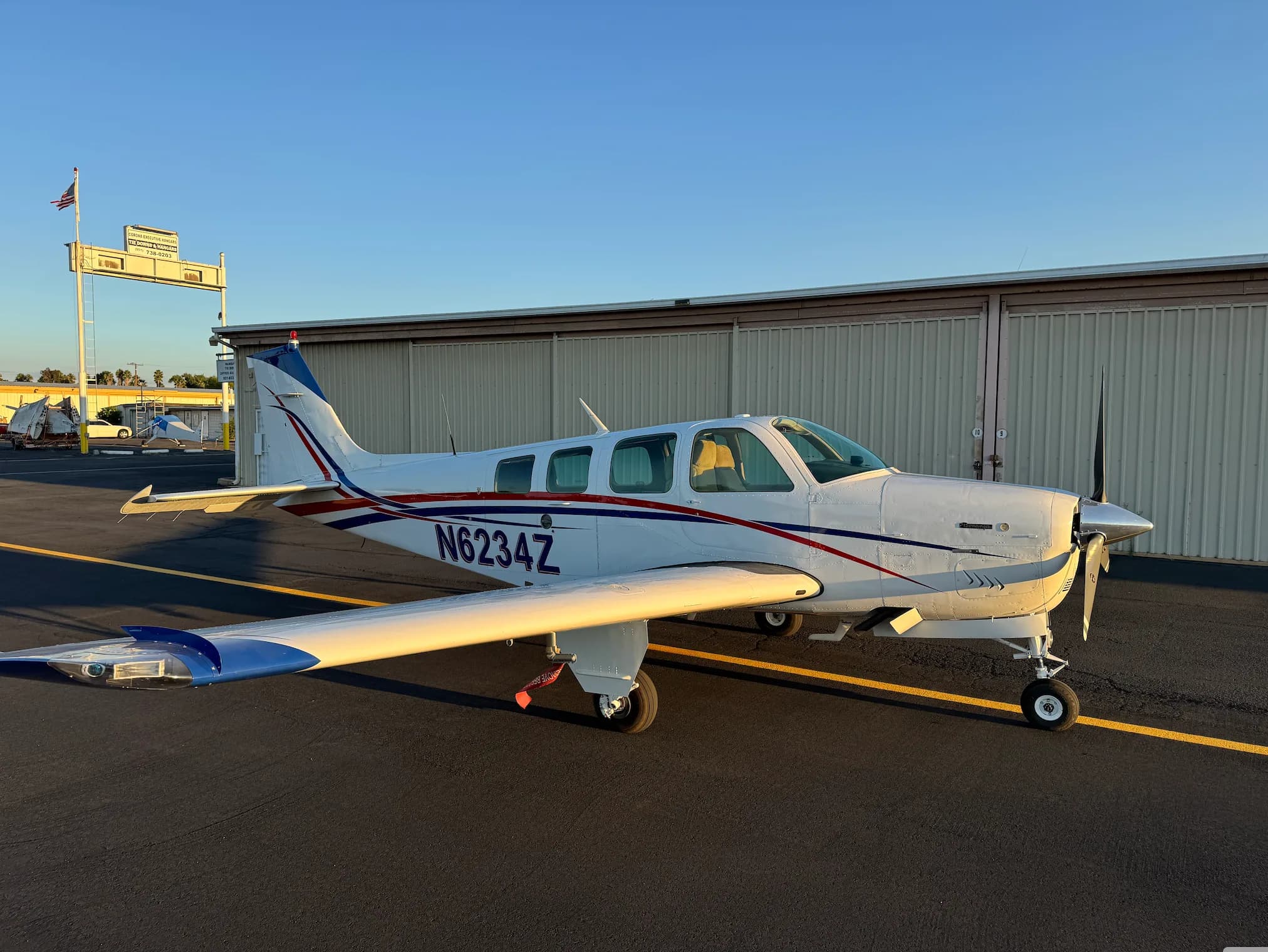 Full view of a white and red Beechcraft Bonanza N6234Z parked on the tarmac.