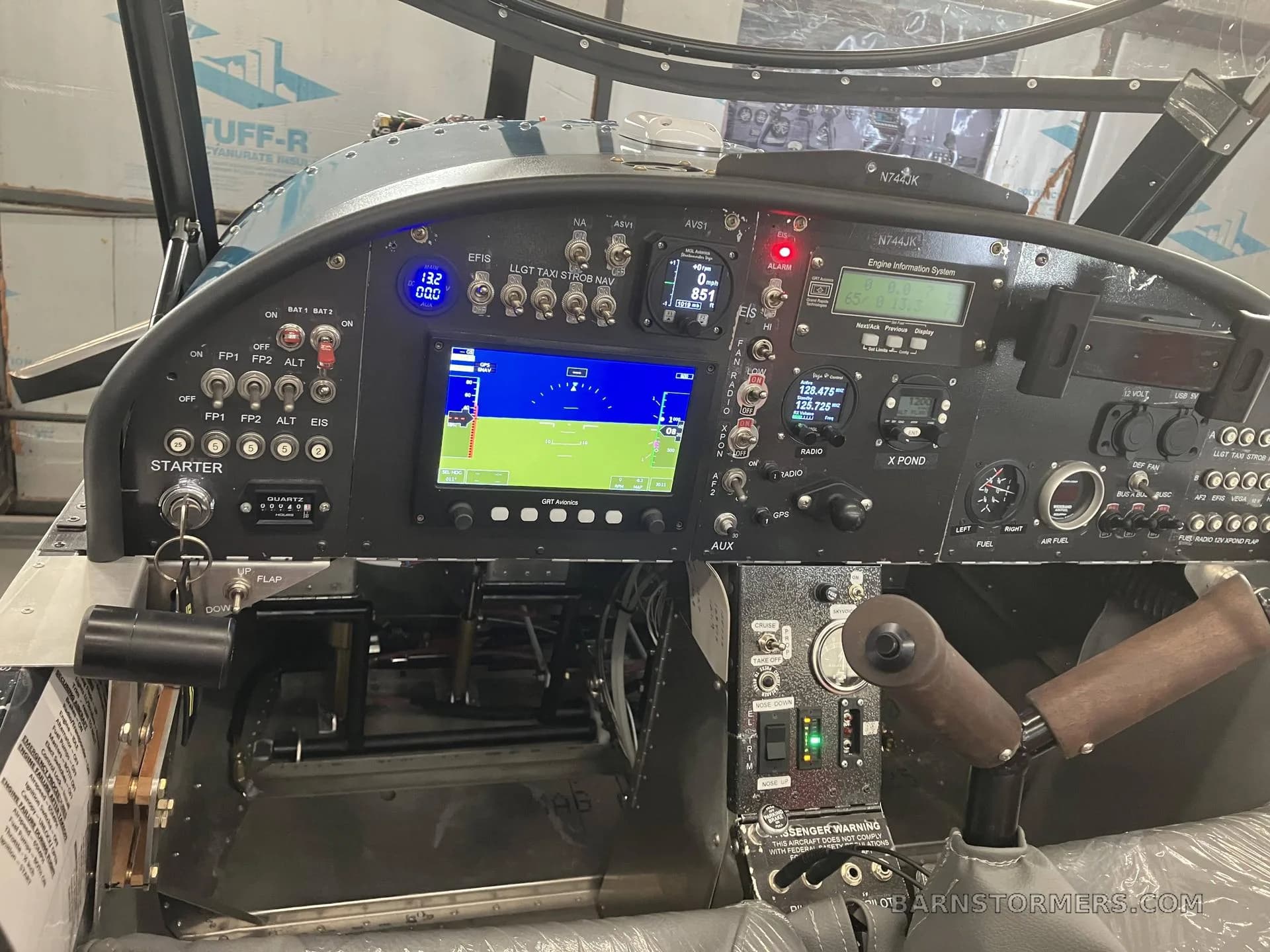 An angled view of the Zenith CH650 cockpit, showing the instrument panel with a powered-on EFIS display and other avionics.
