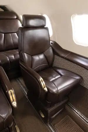 Interior view of the Learjet 45XR cabin with leather seats facing the cockpit.