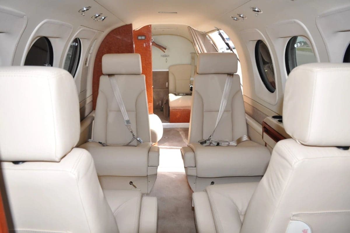 Interior view of the aircraft cabin with cream-colored leather seats.