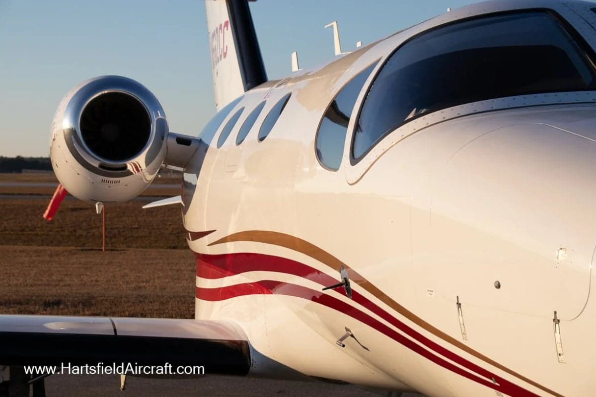 Close up of the nose and engine of a Cessna Citation Mustang with a white and red paint scheme.