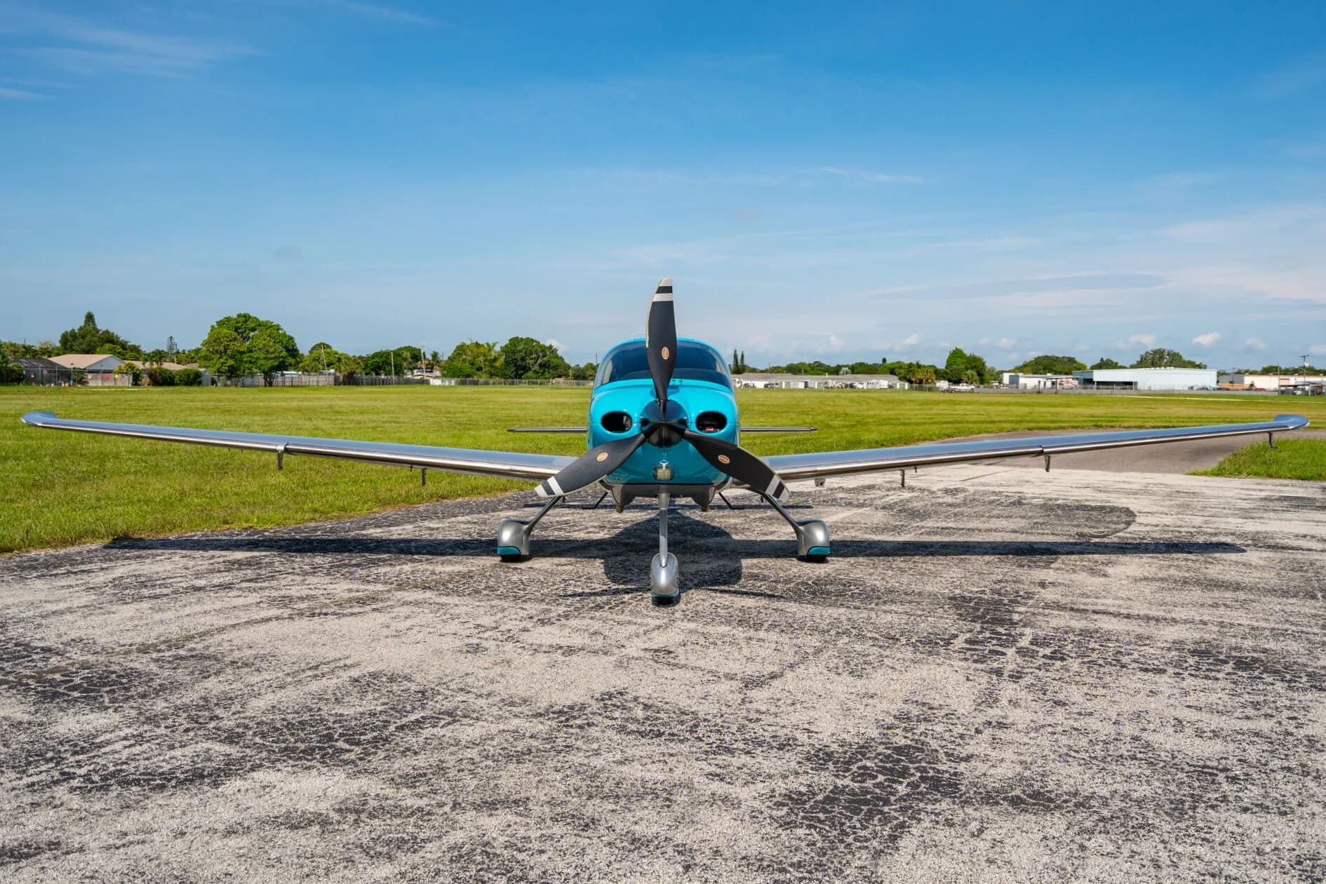A head-on view of a blue and silver Carbon aircraft (N33JG) parked on an asphalt ramp.