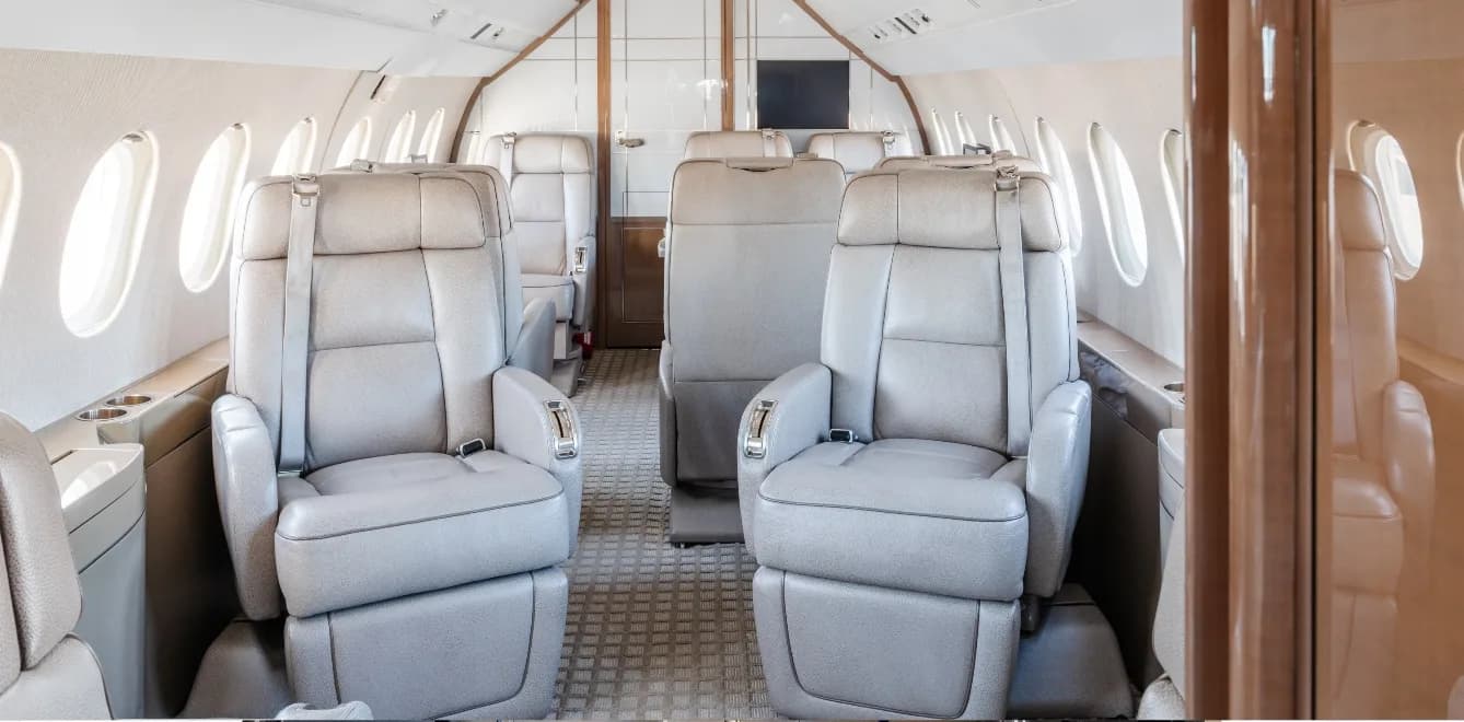 View of the aircraft's interior with light gray leather seats.