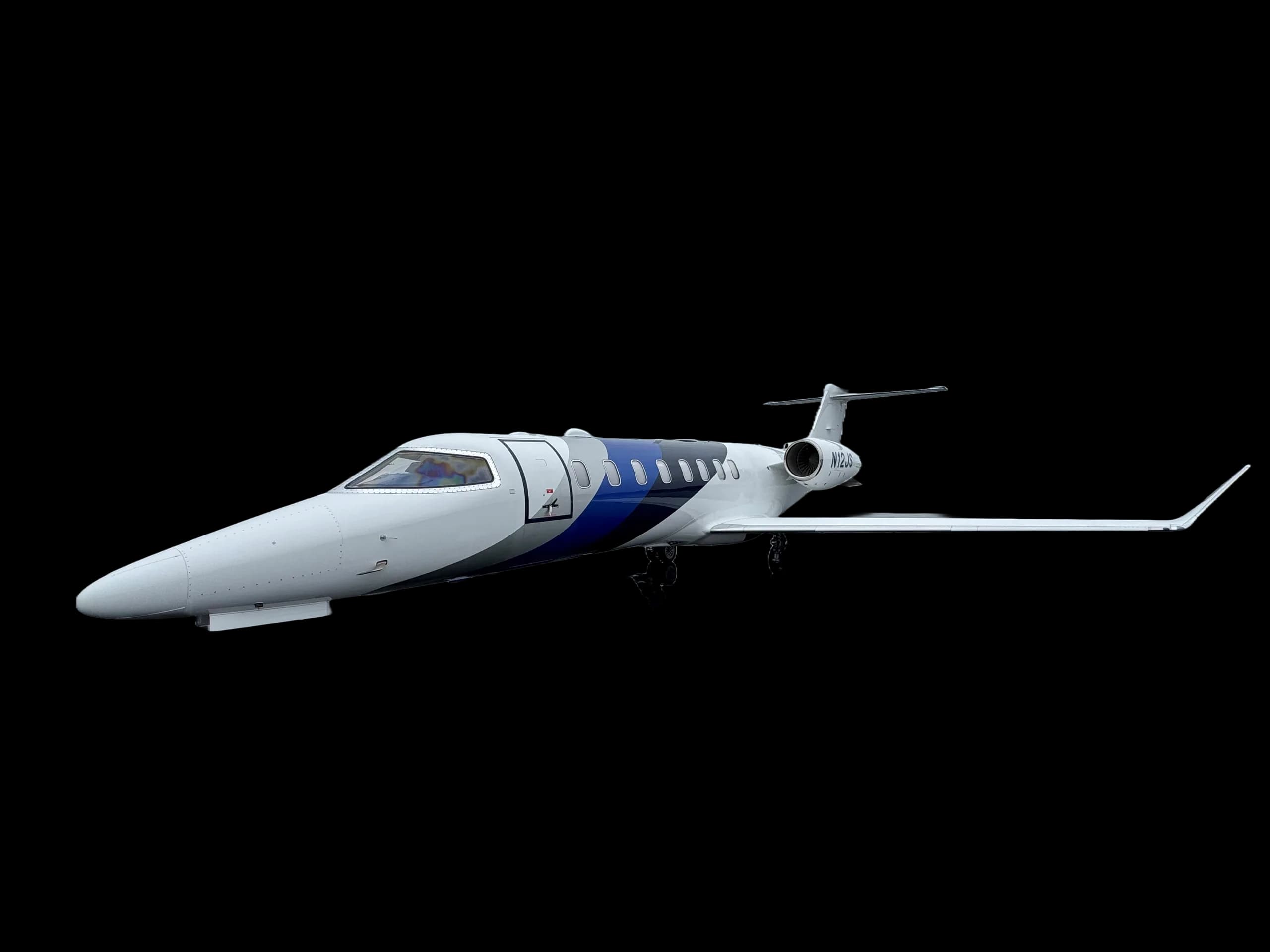 A white and blue jet is parked on a black background.