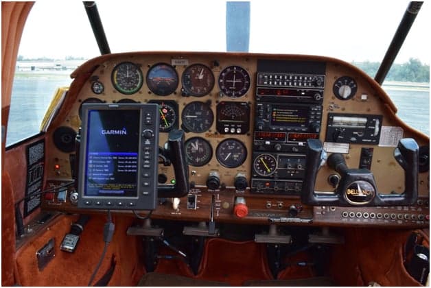 Close-up of the front of a tan and red single-engine aircraft.