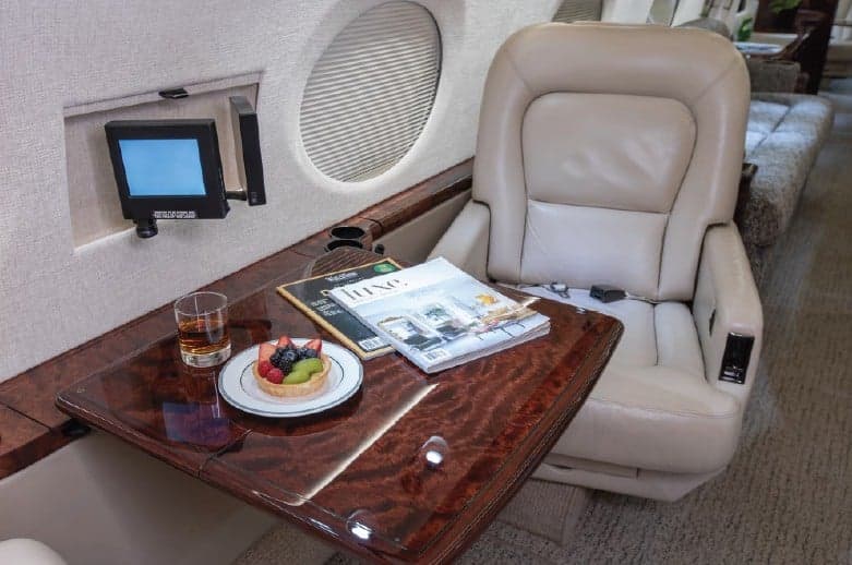 Interior view of the aircraft with a snack and magazine on a table.