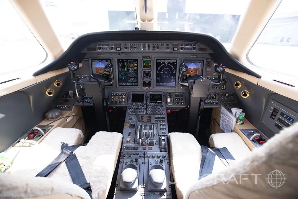 The cockpit of a jet with multiple screens and controls.
