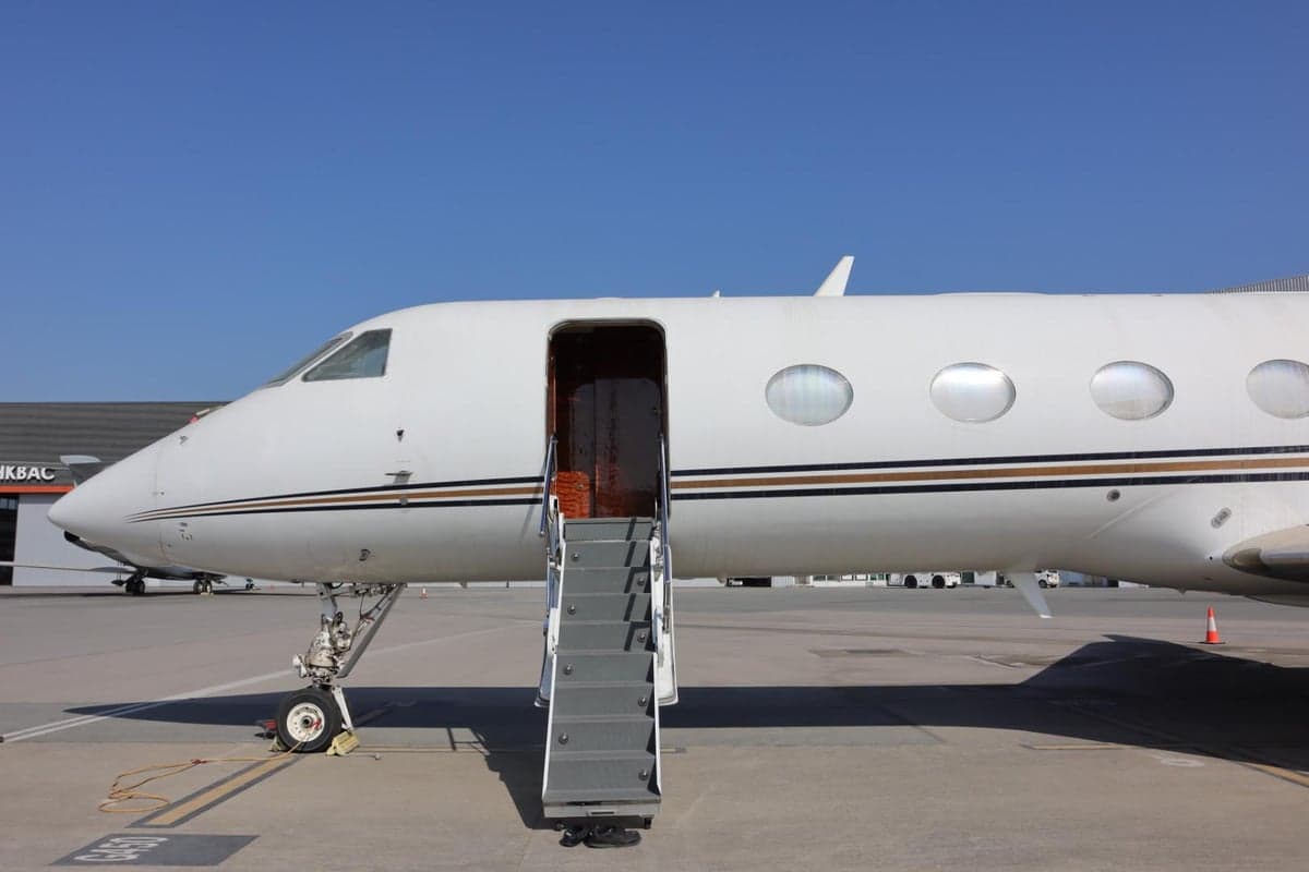 A Gulfstream jet with airstairs extended for boarding.
