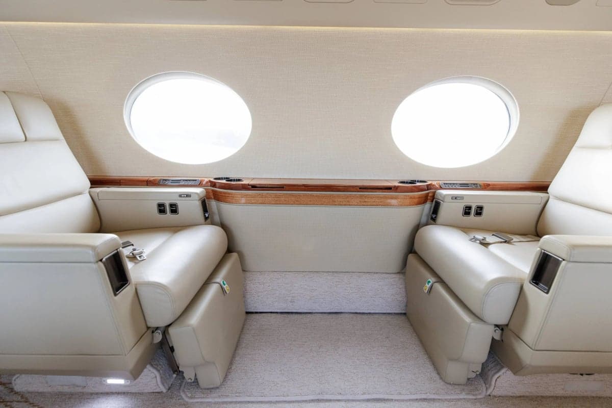 A close-up of the seating arrangement in the Gulfstream G550 cabin, showcasing the leather upholstery and features.