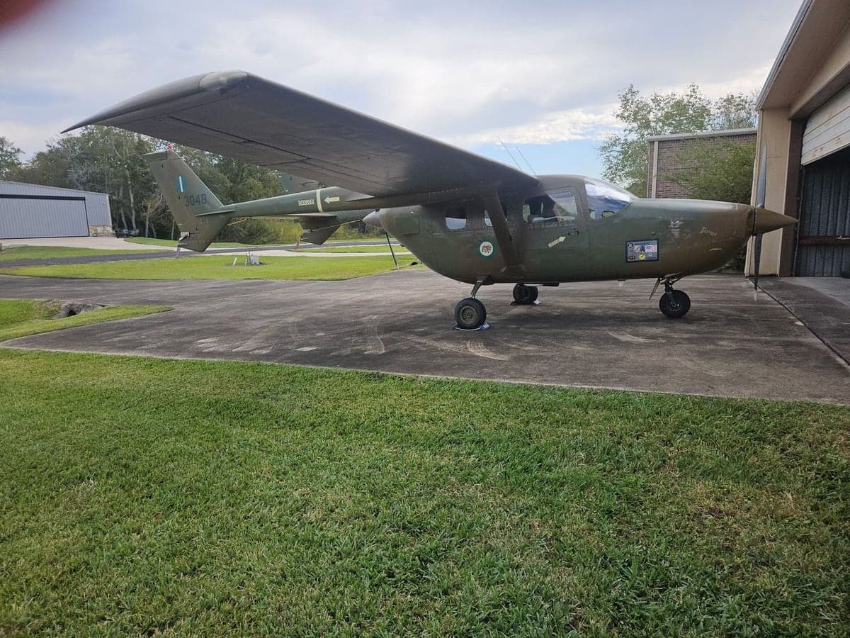 A military-style aircraft with tail number 3048 parked on the tarmac.