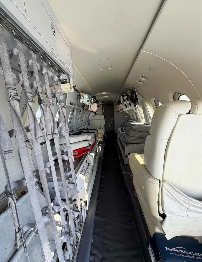 The interior of an air ambulance aircraft, featuring medical equipment, stretchers, and cargo netting.