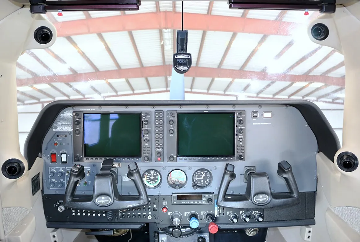 The cockpit of a Cessna Stationair TC aircraft, featuring a modern glass panel display and dual yokes.