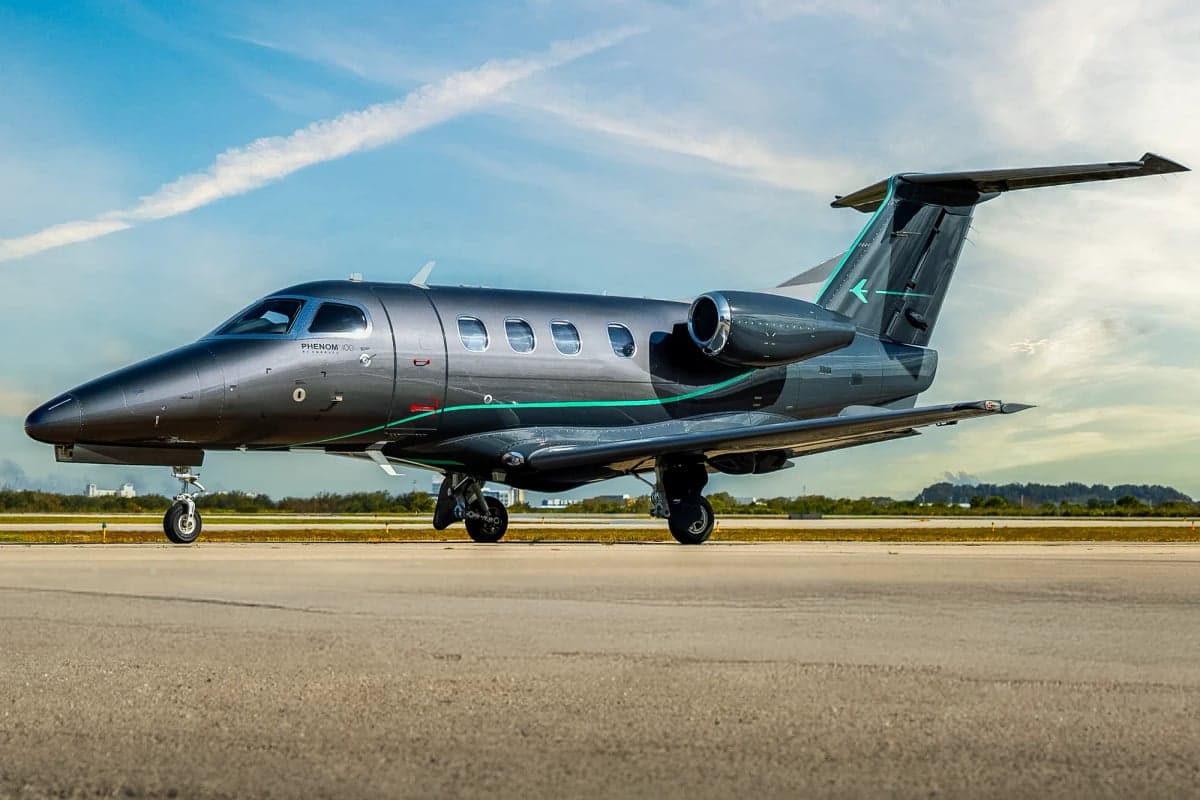 A dark gray Phenom 300E on the tarmac.