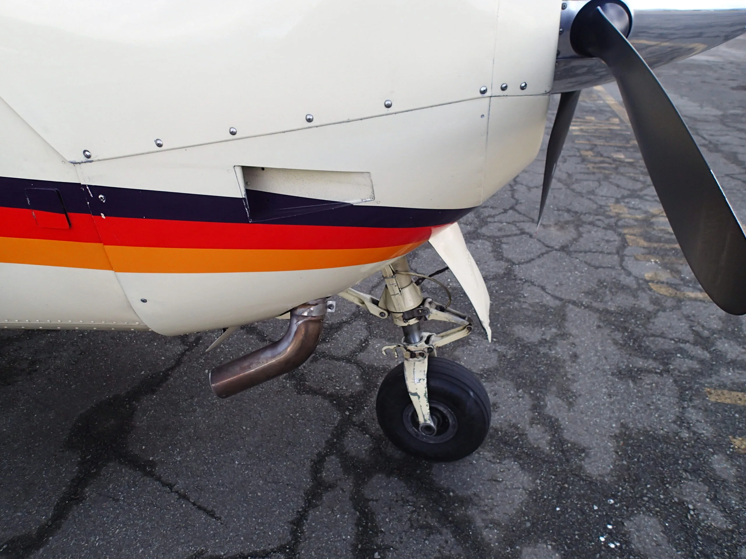 Close up of the landing gear and exhaust of Cessna Cardinal RG C-FBXA.