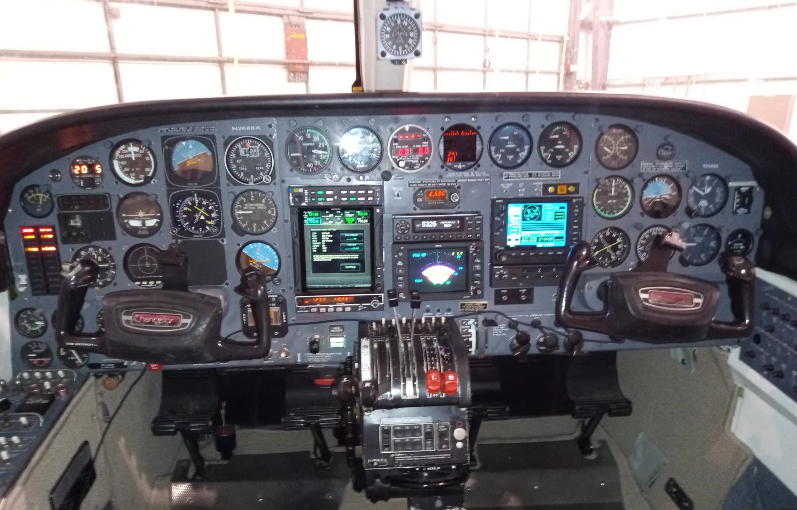A full view of the aircraft's cockpit instrument panel with multiple gauges, screens, and controls.