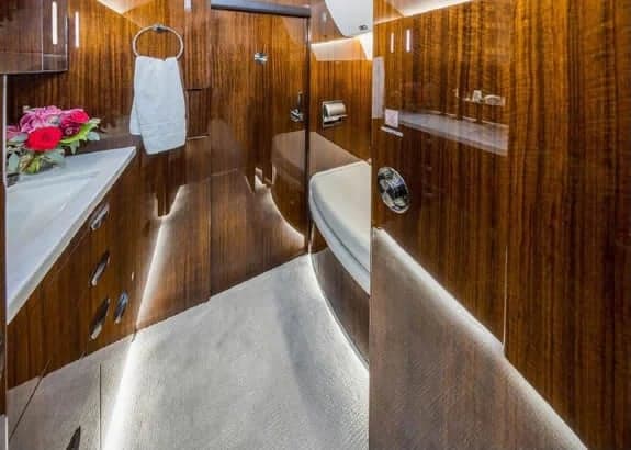 Aircraft lavatory with wood paneling and a white sink.