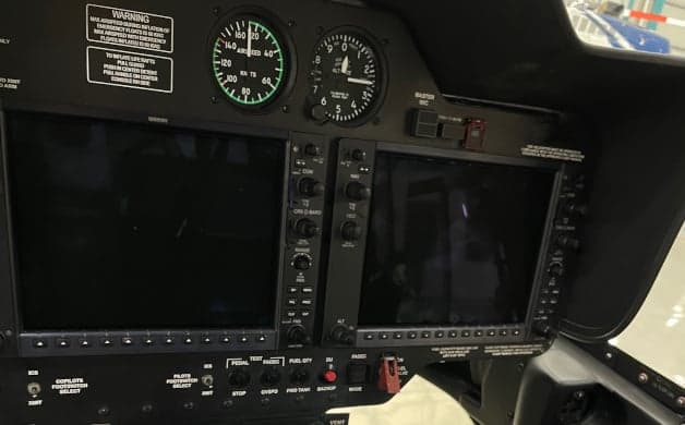 View of the helicopter cockpit with instrument panel and seats.