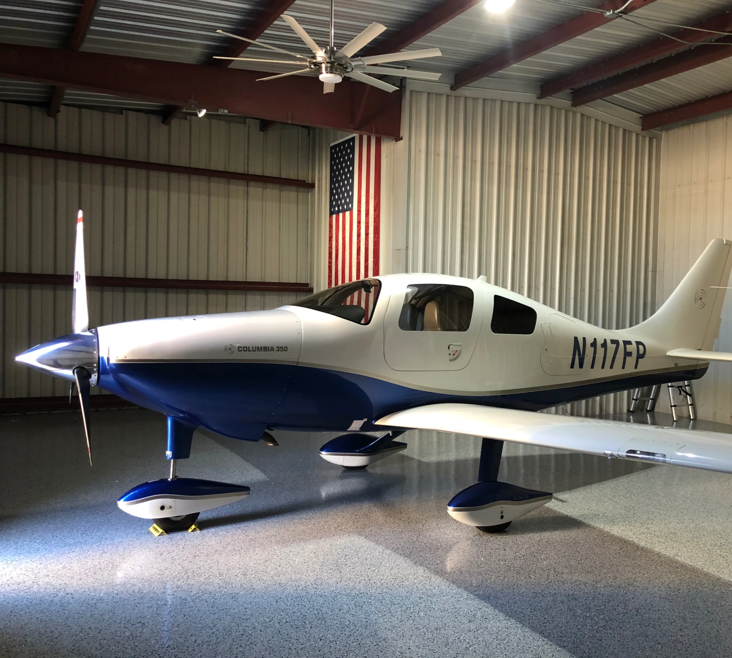 Cirrus SR22 with blue and white paint scheme in a hangar.