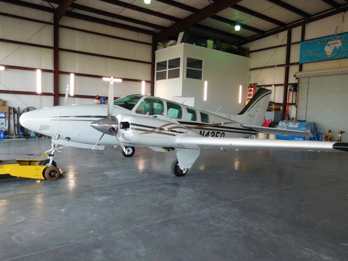 Side view of the Beechcraft Baron N42FQ in a hangar.