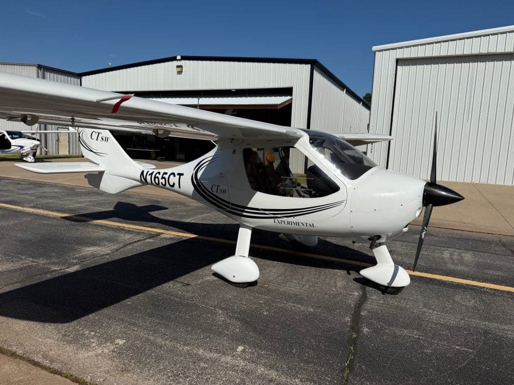 The CTLSW aircraft N165CT is parked on the tarmac in front of a hangar.