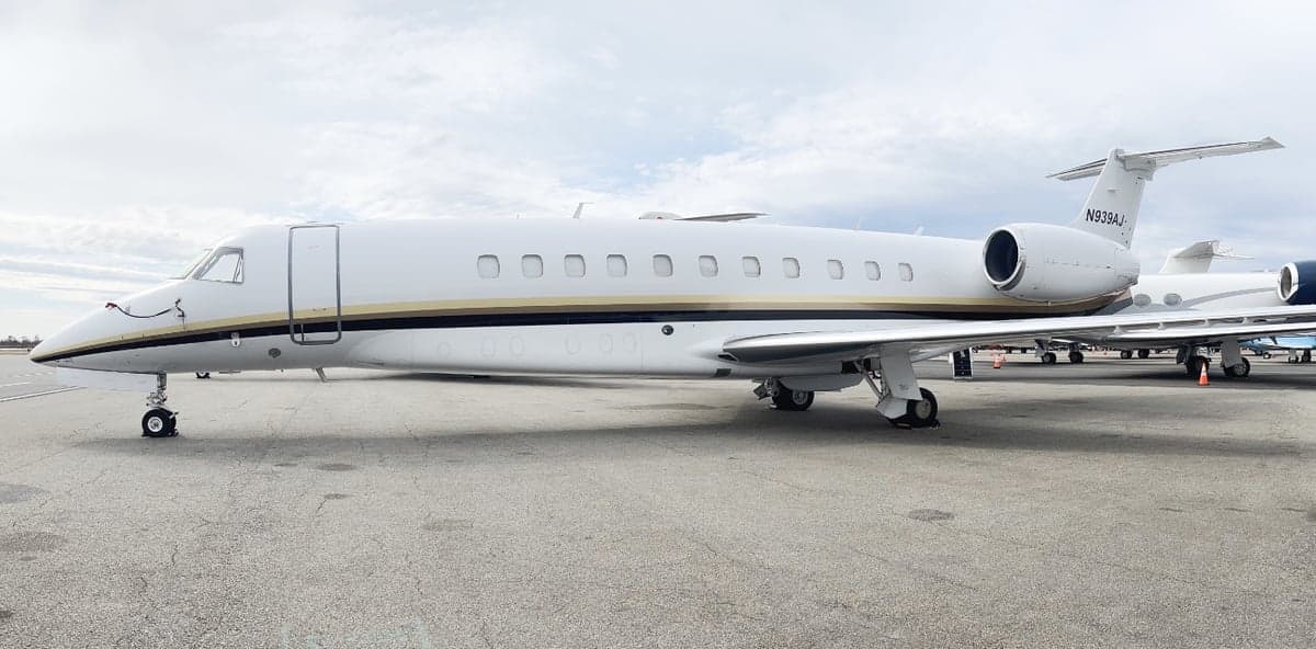 Side view of a white and gold Challenger aircraft on the ground.