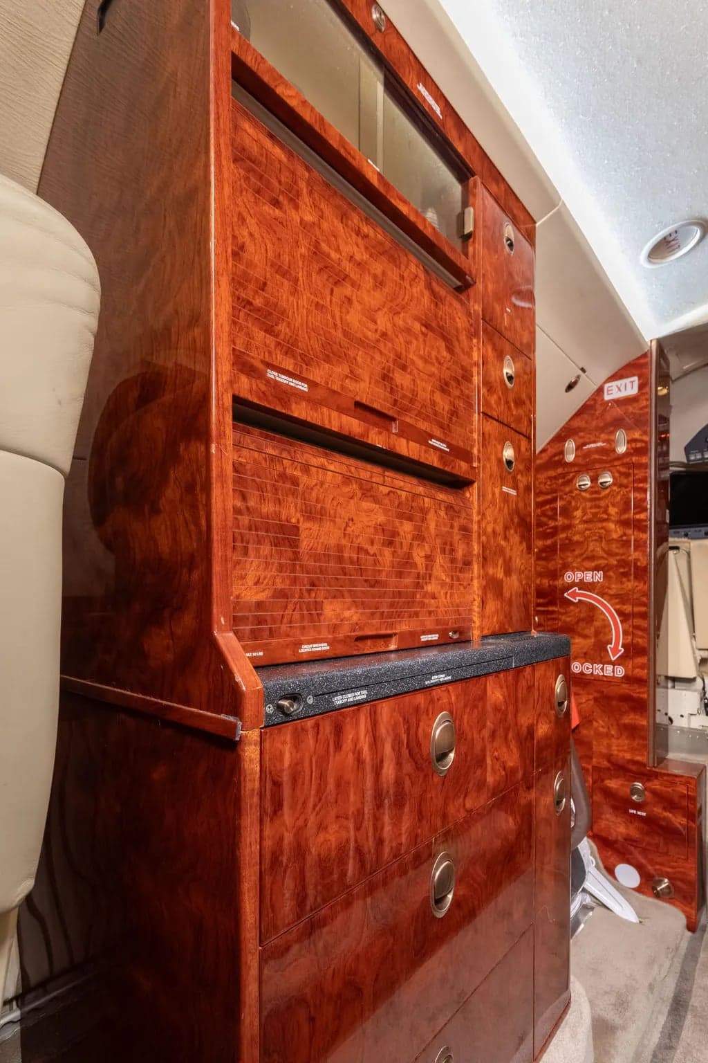 Interior view of the aircraft showing wood cabinetry and storage compartments.