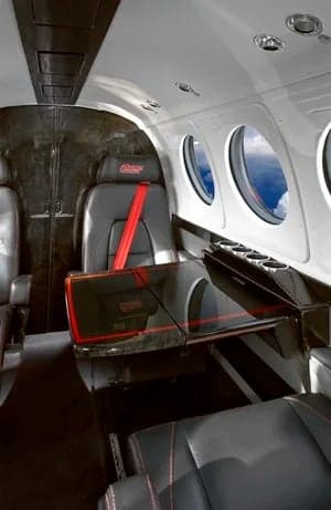 The interior of a King Air aircraft with leather seats and a table.