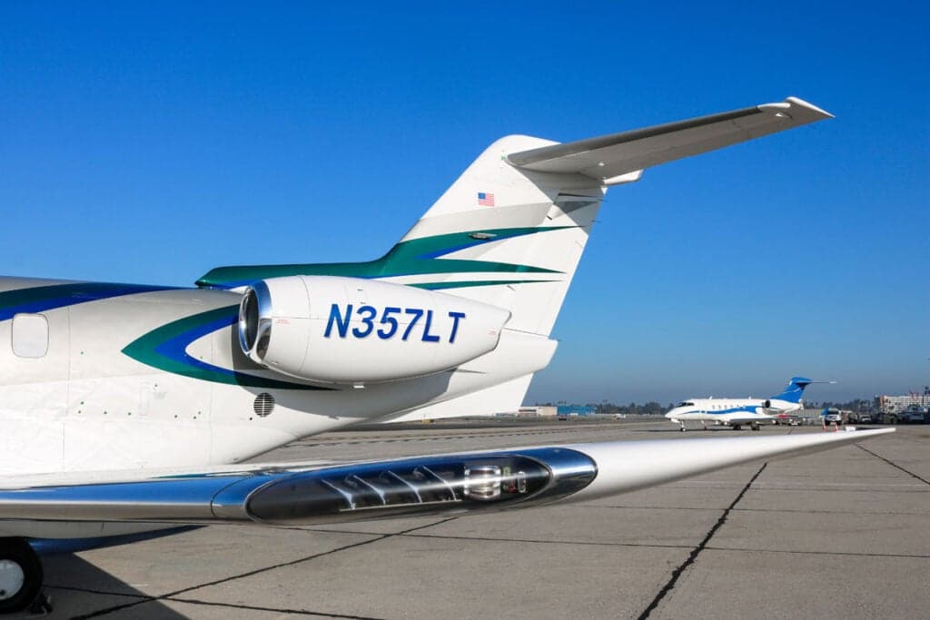 Close-up of the tail section of the Pilatus PC-24 N357LT with a white and teal paint scheme.