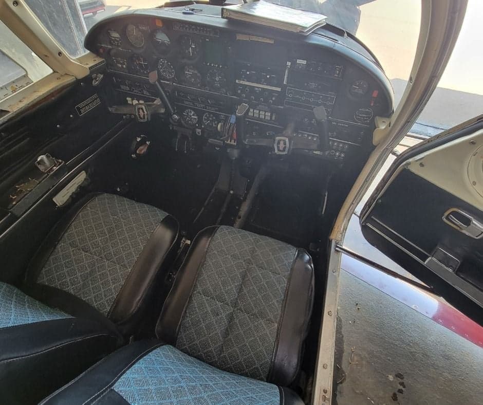 View of the cockpit and front seats of an aircraft, showing the instrument panel and controls.