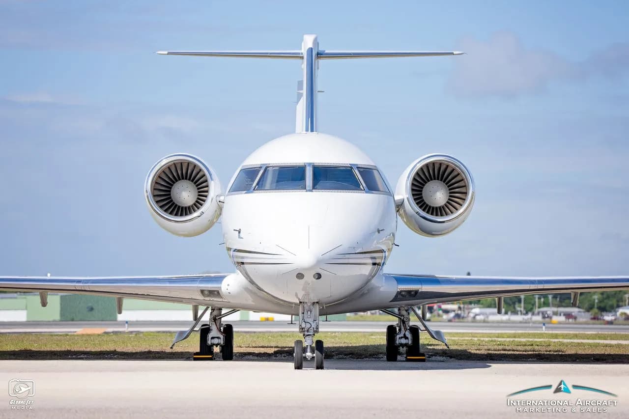 Front view of a white jet aircraft on the tarmac.