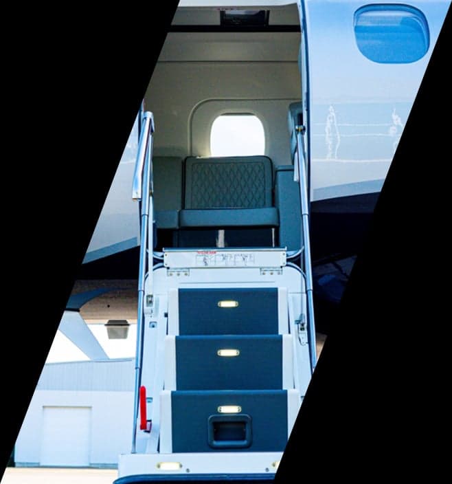The open main cabin door and integrated airstairs of an Embraer Phenom 300E jet.