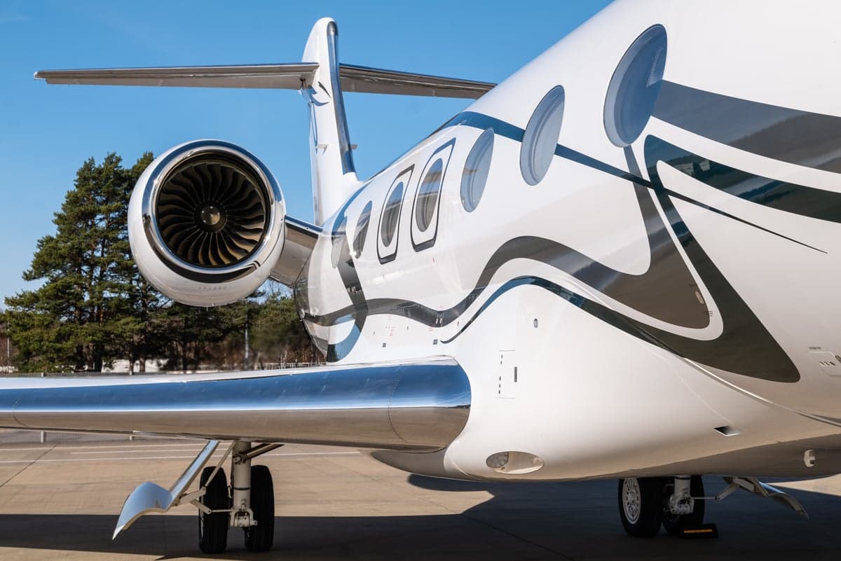 Close-up of the Gulfstream aircraft's engine, wing, and fuselage with a distinctive paint scheme.