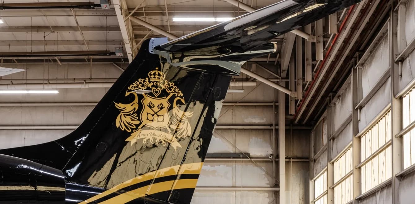 Close-up of the tail of the black and gold aircraft, showing a custom crest design.