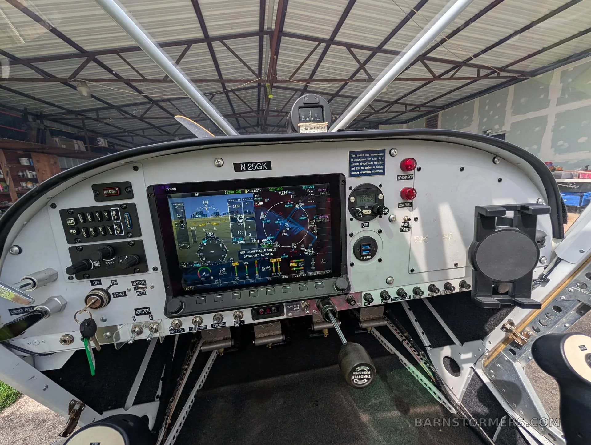 A close-up view of a modern aircraft cockpit featuring a large digital display and various controls, with the registration N25GK visible.