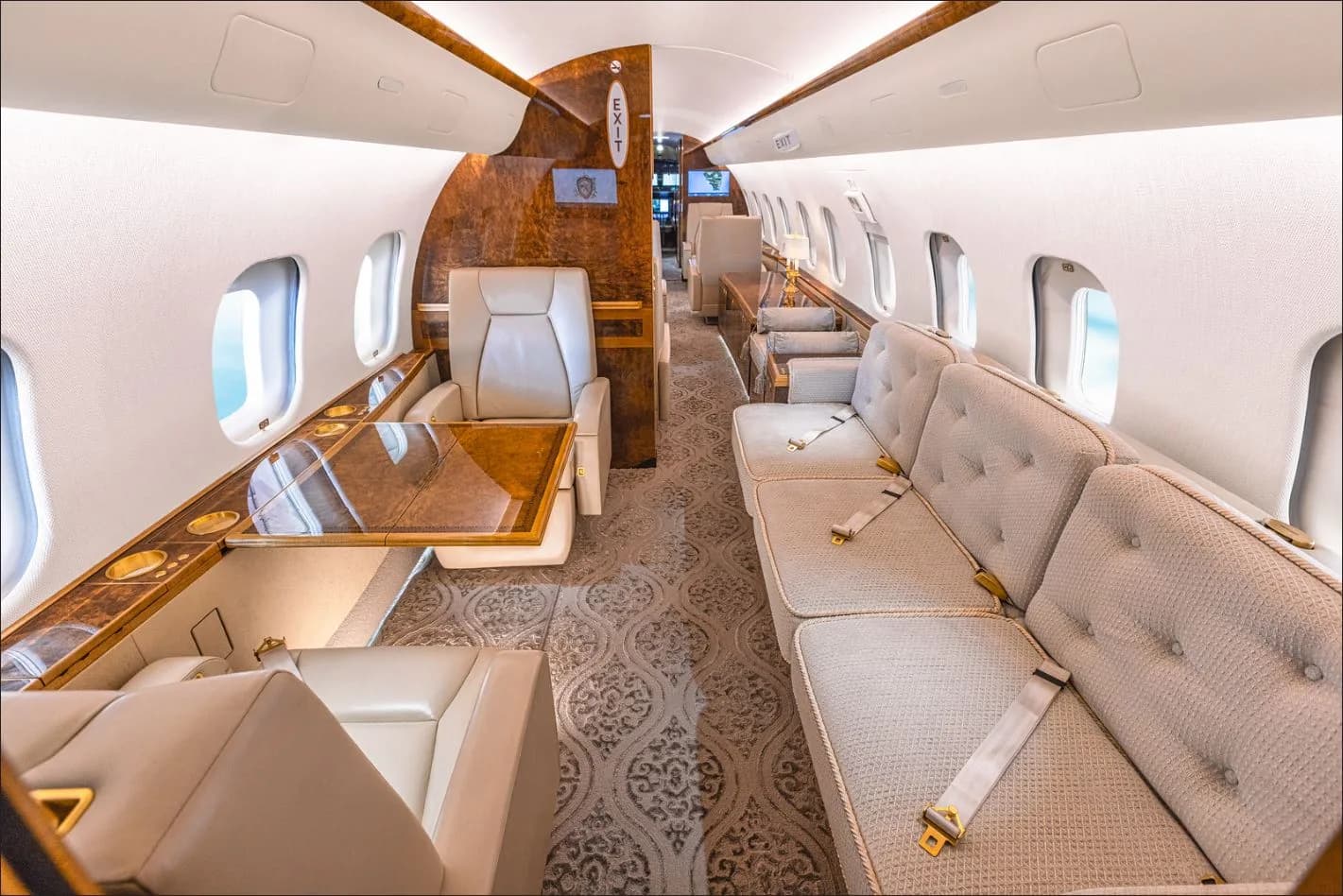 View of the aircraft's interior with cream-colored seats and wood accents.