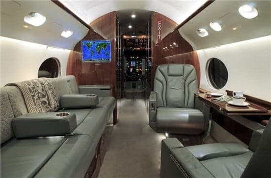 The aircraft's interior features leather seats and wood paneling.