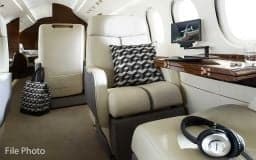 Interior of the Falcon jet with a comfortable seat and entertainment system.